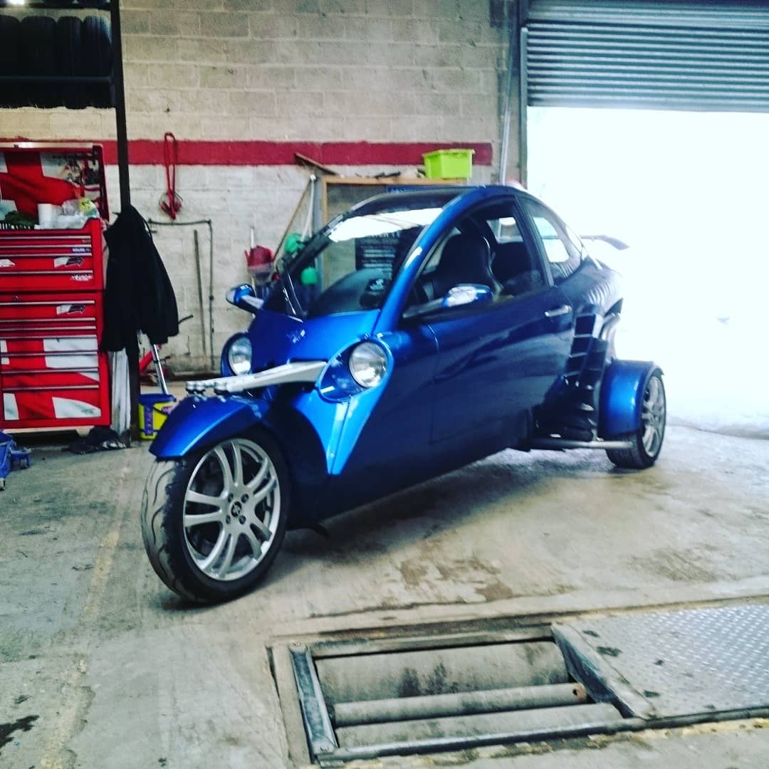 Blue three-wheeled vehicle inside the workshop